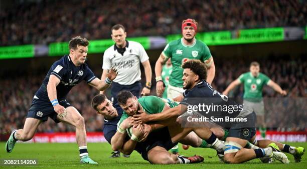 Dublin , Ireland - 16 March 2024; Robbie Henshaw of Ireland is held up by Scotland players from left, George Horne, Cameron Redpath, and Andy...