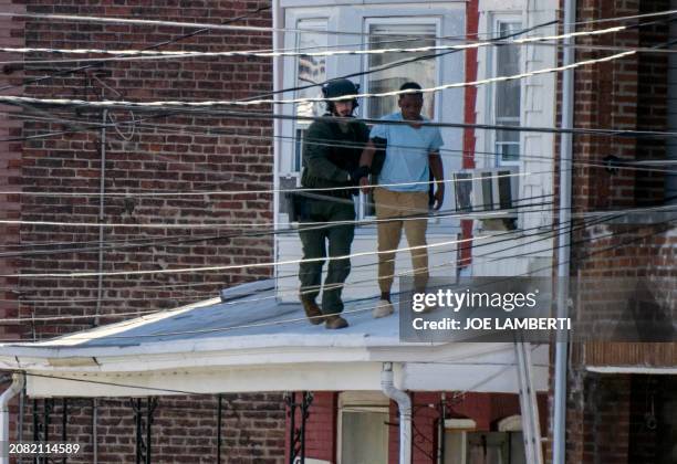 Police remove people from a home in Trenton New Jersey, on March 16 after reports of a gunman, who is suspected of a shooting spree in Pennsylvania,...