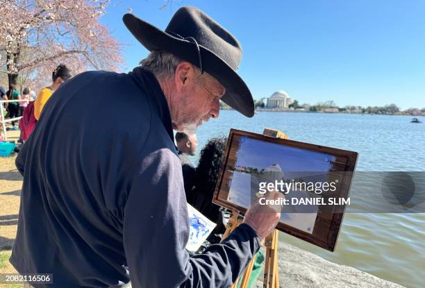 Painter works on his image of the Tidal Basin and Jefferson Memorial during Cherry Blossoms season on the National Mall in Washington, DC, on March...