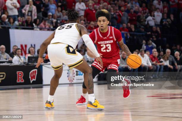 Wisconsin Badgers guard Chucky Hepburn dribbles while being defended by Purdue Boilermakers guard Lance Jones during overtime of a Big Ten Men's...