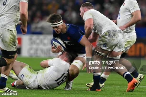 France's flanker Alexandre Roumat is tackled by England's hooker Theo Dan during the Six Nations international rugby union match between France and...