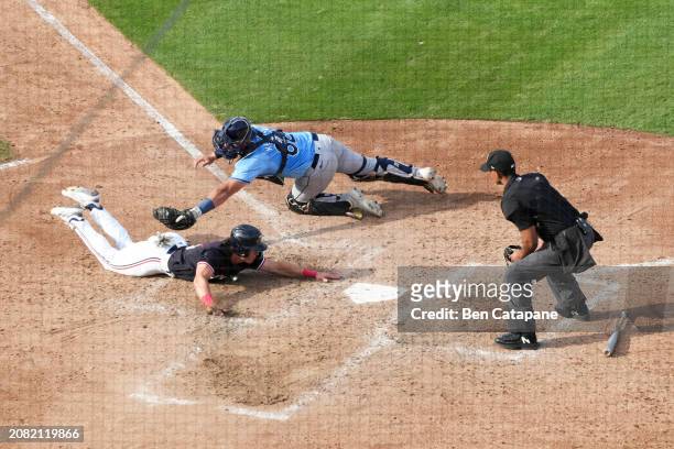 Luke Keaschall of the Minnesota Twins slides safely into home plate to score in the third inning during the 2024 Spring Breakout Game between the...
