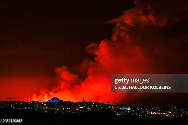 The skyline of Reykjavik is against the backdrop of orange coloured sky due to molten lava flowing out from a fissure on the Reykjanes peninsula...