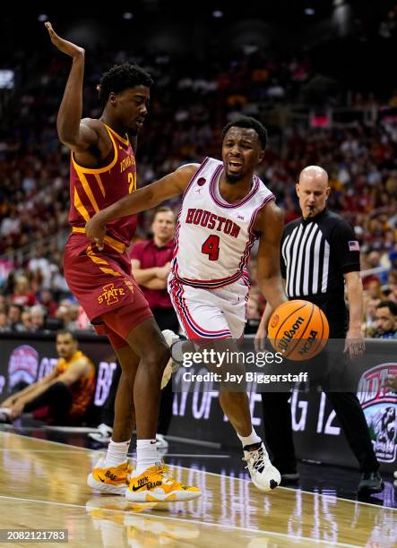 Cryer of the Houston Cougars drives against Hason Ward of the Iowa State Cyclones during the first half of the Big 12 Men's Basketball Tournament...