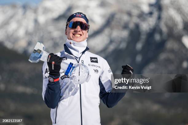 Johannes Thingnes Boe of Norway with the trophy for the pursuit world cup score after the Men 12.5 km Pursuit at the BMW IBU World Cup Biathlon on...