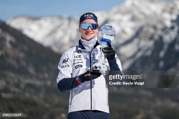 Johannes Thingnes Boe of Norway with the trophy for the pursuit world cup score after the Men 12.5 km Pursuit at the BMW IBU World Cup Biathlon on...