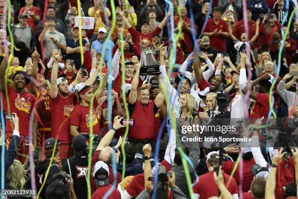 Streamers fall as Iowa State Cyclones head coach T.J. Otzelberger lifts the trophy over his head after winning the Big 12 tournament final against...