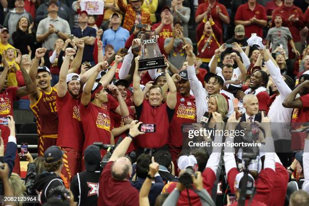 Iowa State Cyclones head coach T.J. Otzelberger lifts the trophy over his head after winning the Big 12 tournament final against the Houston Cougars...