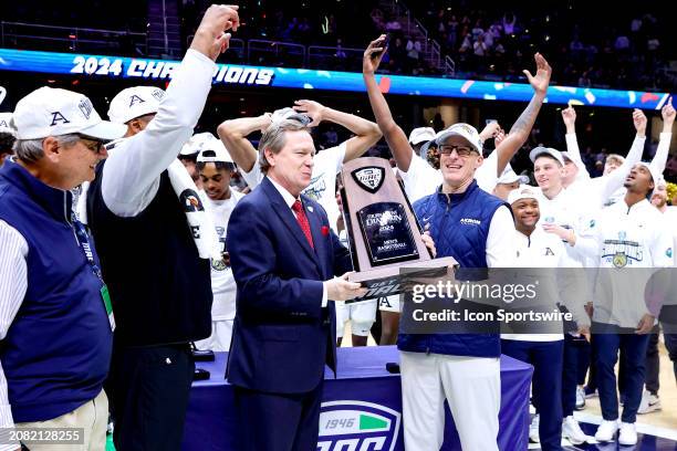 Mid-American Conference Commissioner Dr. Jon A.Steinbrecher presents the MAC tournament trophy to Akron Zips head coach John Groce and the Akron Zips...