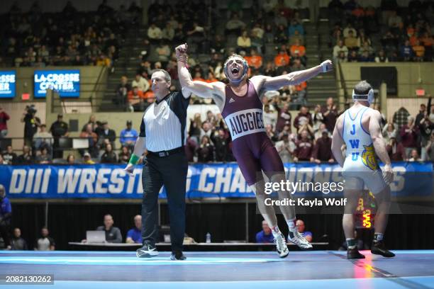 Bentley Schwanebeck-Ostermann of the Augsburg University Eagles celebrates winning the 184 lb. Weights class and defeating Ryan DeVivo of the Johnson...