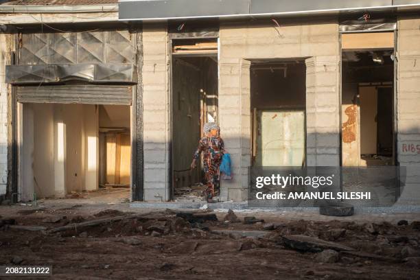 Woman walks past dismantled storefronts during a planned demolition in the historical Piazza neighbourhood of Addis Ababa on March 17, 2024. The city...