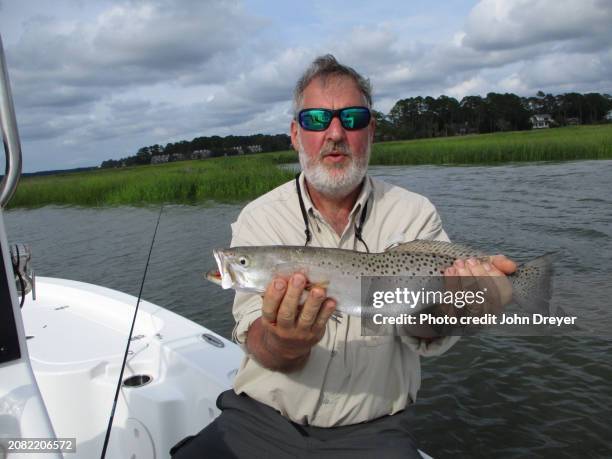 fisherman with nice sea trout - trout stock pictures, royalty-free photos & images