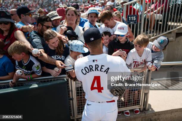 Carlos Correa of the Minnesota Twins signs autographs for fans during a spring training game against the St. Louis Cardinals on March 13, 2024 at the...