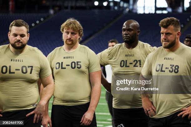 Cooper Beebe #OL07 of Kansas State, Karsen Barnhart #OL05 of Michigan, Jeremy Flax #OL21 of Kentucky, and Trevor Keegan #OL38 of Michigan listen to...