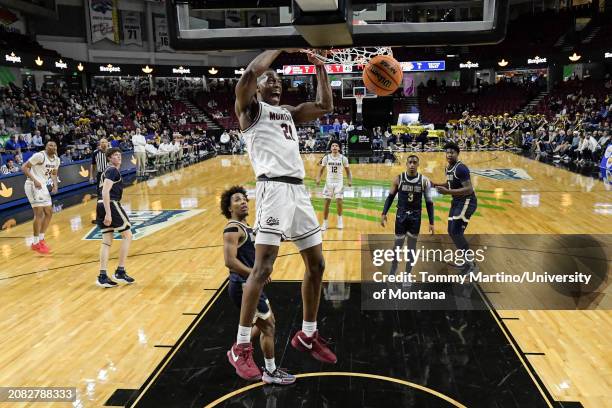 Laolu Oke of the Montana Grizzlies slam dunks in the second half against the Montana State Bobcats during the Big Sky Conference championship game at...