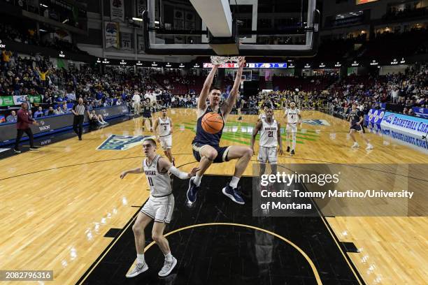 John Olmsted of the Montana State Bobcats slam dunks over Aanen Moody of the Montana Grizzlies in the first half during the Big Sky Conference...