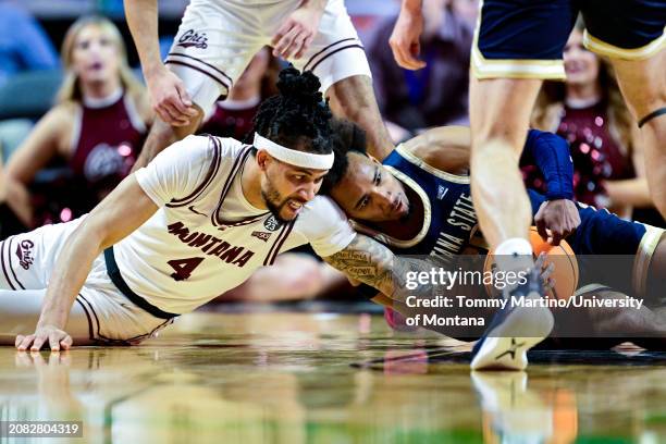 Giordan Williams of the Montana Grizzlies and Robert Ford III of the Montana State Bobcats fight for a loose ball in the first half during the Big...