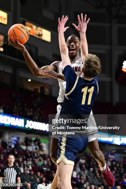 Laolu Oke of the Montana Grizzlies works to shoot the ball over Tyler Patterson of the Montana State Bobcats in the first half during the Big Sky...