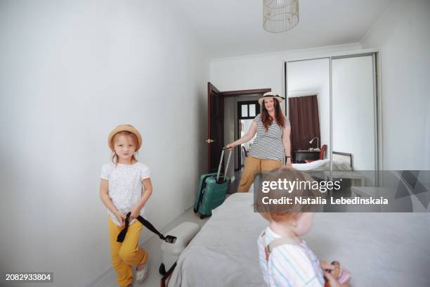 family retreat: mom and two children with suitcase check into hotel room - hotel confirmation stock pictures, royalty-free photos & images