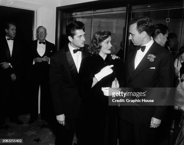 Married couple, actors John Drew Barrymore and Cara Williams , chatting to American businessman Huntington Hartford during a film premiere at...