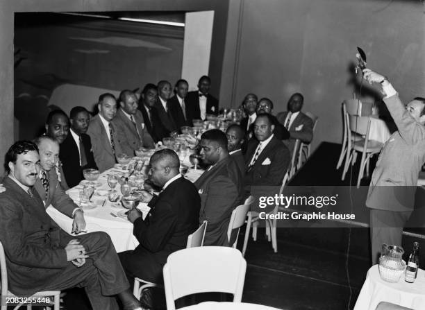 American Baptist pastor and politician Adam Clayton Powell Jr with friends and family at his stag do party, US, circa 1945.