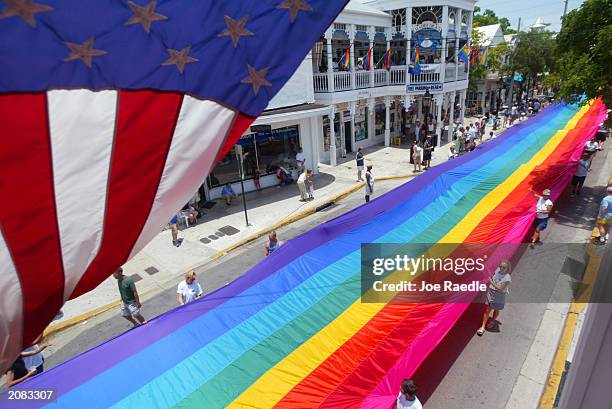 Volunteers help stretch the mile and quarter long "World's longest Rainbow Flag" June 15, 2003 from the Gulf of Mexico to the Atlantic coast along...