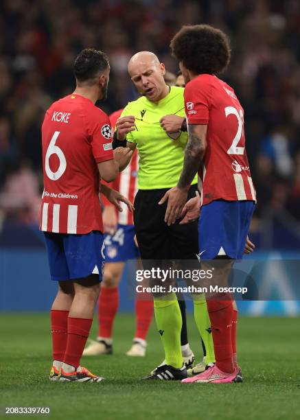 Koke and Axel Witsel of Atletico Madrid discuss with the Referee Szymon Marciniak of Poland during the UEFA Champions League 2023/24 round of 16...