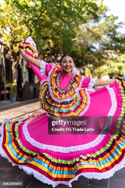 portrait of a young woman dancing with traditional mexican clothing outdoors - jarabe tapatío stock pictures, royalty-free photos & images