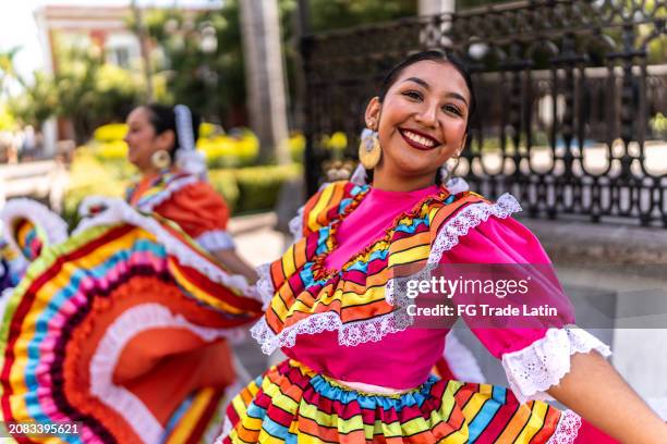 retrato de una mujer joven bailando en el festival tradicional en el parque público - guadalajara méxico fotografías e imágenes de stock