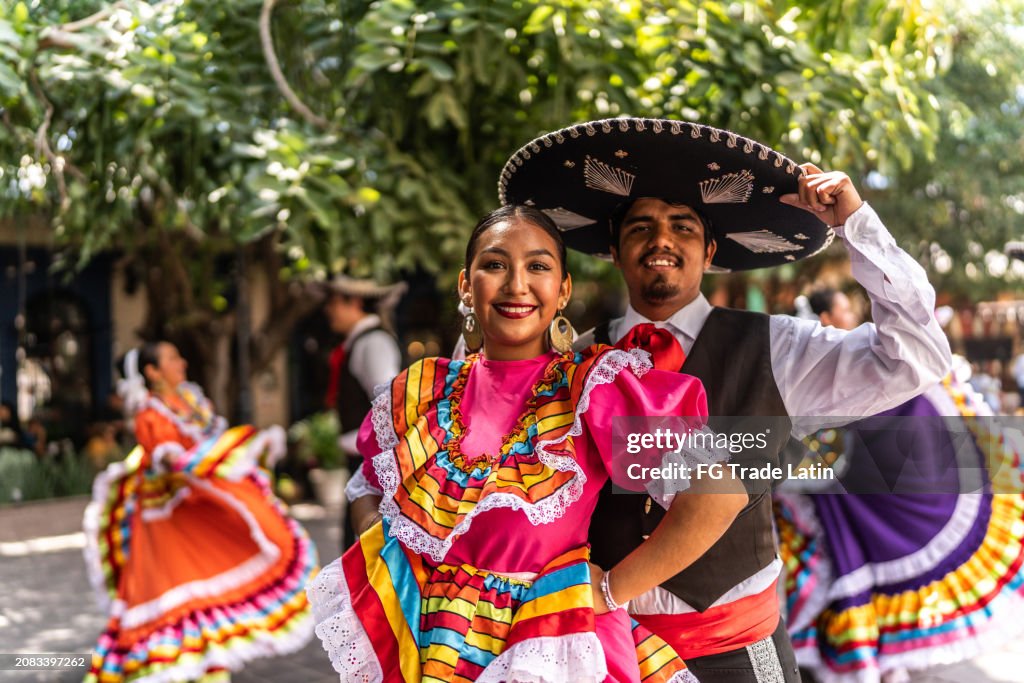 Portrait of a young couple dancing in traditional festival at public park