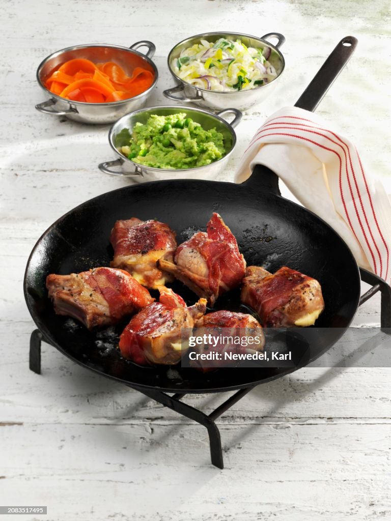 Suckling pig chops wrapped in ham with a cheese filling
