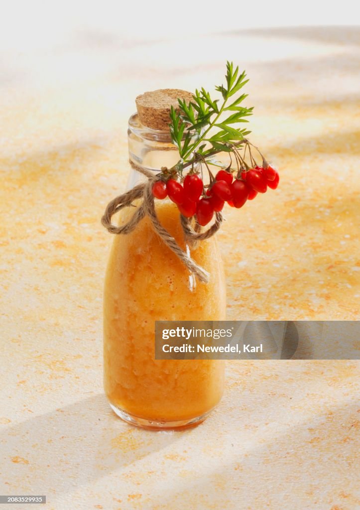 A pineapple and carrot smoothie with orange juice and goji berries