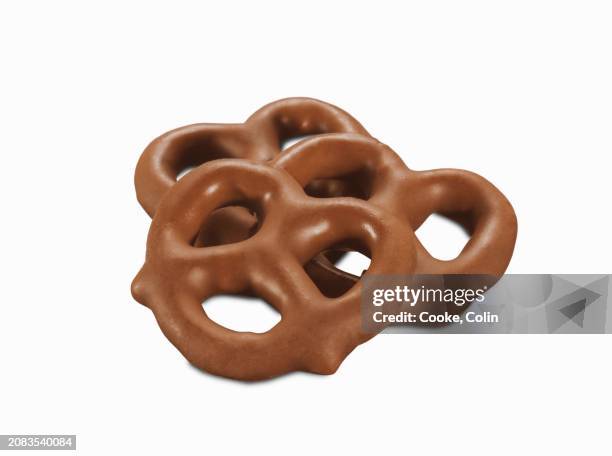 three milk chocolate pretzels (close-up) - pretzel stockfoto's en -beelden