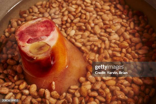 dried pinto beans with a ham hock in a pot - chispes - fotografias e filmes do acervo