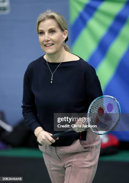 Sophie, Duchess of Edinburgh smiles as she takes part in a badminton match at the All England Open Badminton Championships with Prince Edward, Duke...