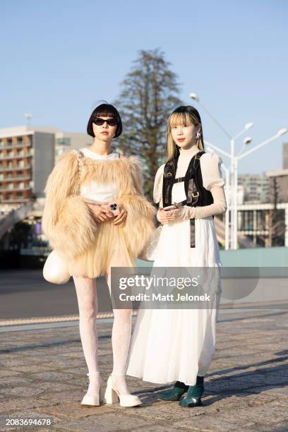 Guests are seen wearing a beige feather jacket and skirt, white boots and bag; a white dress with black vest during the Rakuten Fashion Week TOKYO...