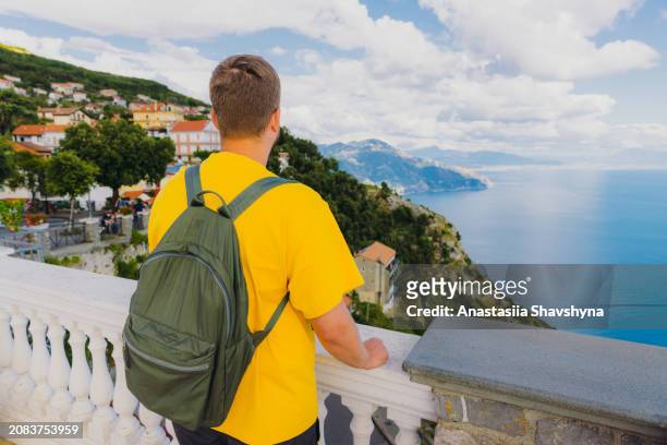 man with backpack contemplating scenic view from above of amalfi coast, italy - amalfi hike stock pictures, royalty-free photos & images