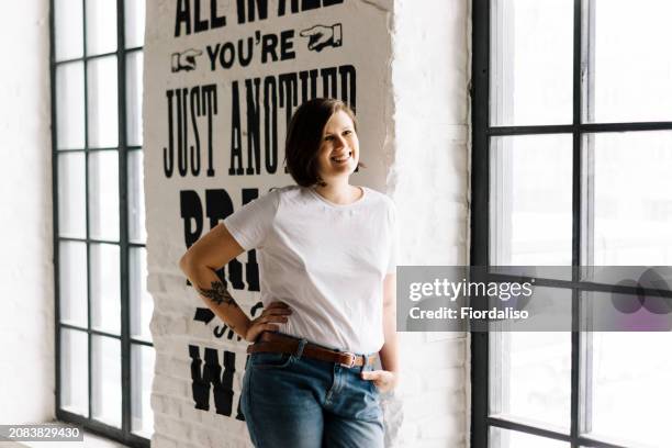 attractive woman with a short half-haircut in a white t-shirt and jeans - international womens day 2019 stock pictures, royalty-free photos & images