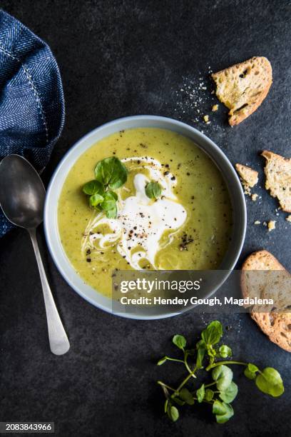 a bowl of pea and watercress soup with sour cream and bread - pea soup stock pictures, royalty-free photos & images