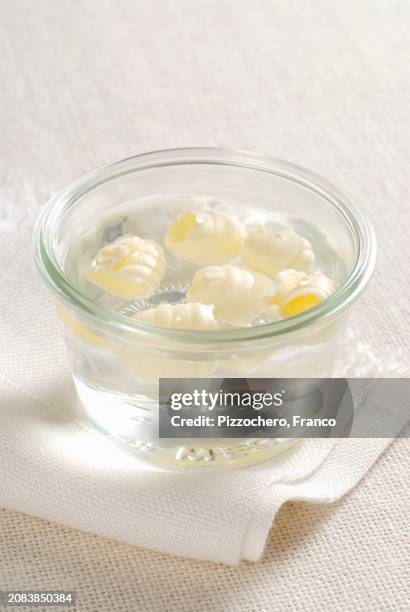 butter rolls in a bowl with water - butter curl stock pictures, royalty-free photos & images