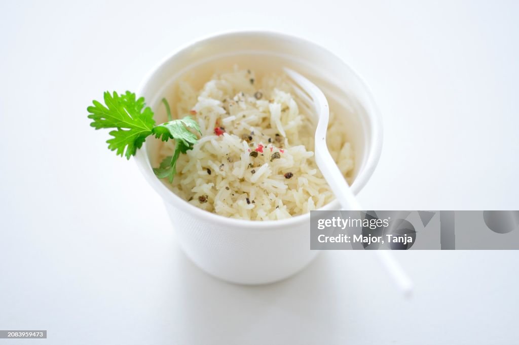 Rice with pepper and parsley in a takeaway pot