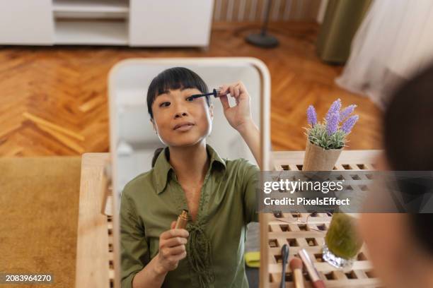 femme mettant du mascara dans le salon - maquillage-des-yeux photos et images de collection