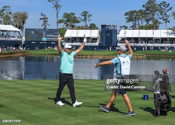 Ryan Fox of New Zealand celebrates after holing his tee shot on the 17th hole for a hole in one as his caddie Dean Smith reacts during the first...