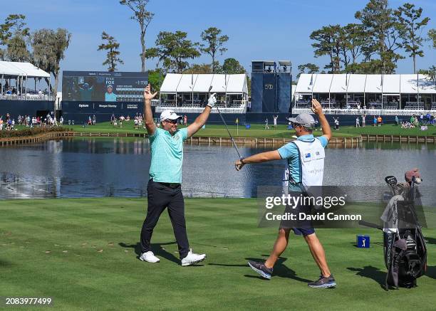 Ryan Fox of New Zealand celebrates after holing his tee shot on the 17th hole for a hole in one as his caddie Dean Smith reacts during the first...