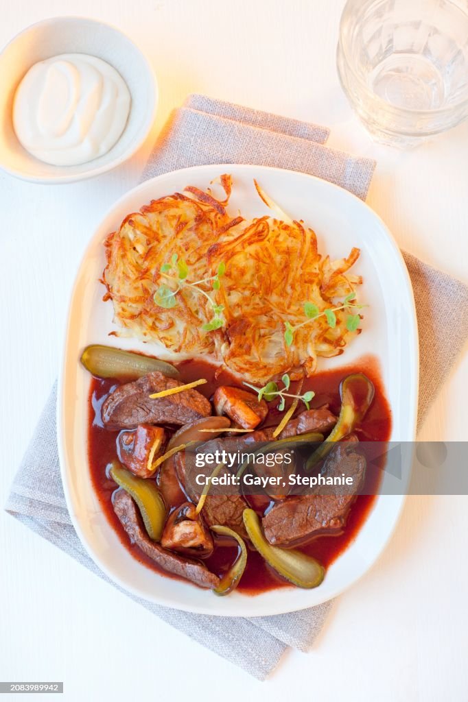 Beef stroganoff with potato rosti, gherkins and mushrooms in red wine sauce
