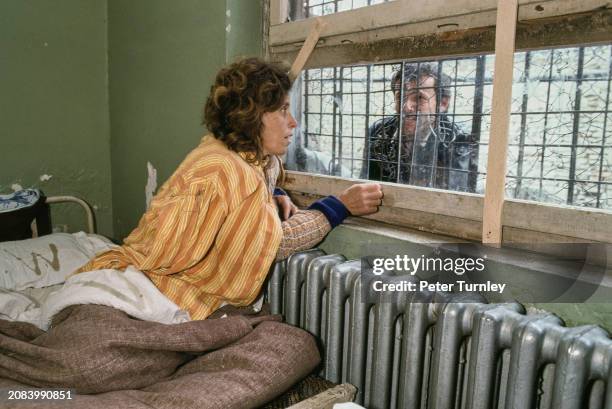 Female patient talking with a man through the window of her room in the Elbasan psychiatric hospital, Albania, 1992.