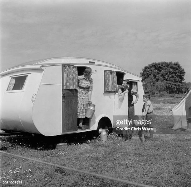 British politician and Member of Parliament Richard Acland with his wife Anne and son Henry near their temporary home, a caravan parked near the...
