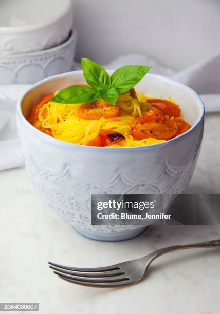 gluten-free capellini pasta with roasted tomatoes and basil in a bowl - tomatenpasta stockfoto's en -beelden