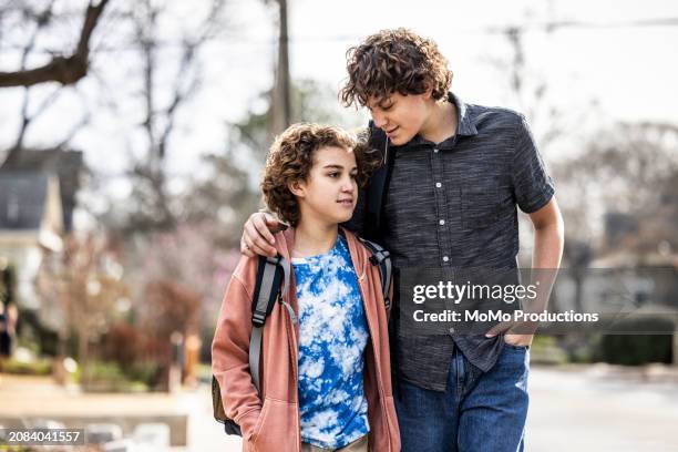 teenage brothers walking down suburban street - momo challenge stock pictures, royalty-free photos & images