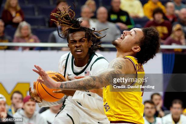Coen Carr of the Michigan State Spartans commits an offensive foul against Braeden Carrington of the Minnesota Golden Gophers in the first half in...